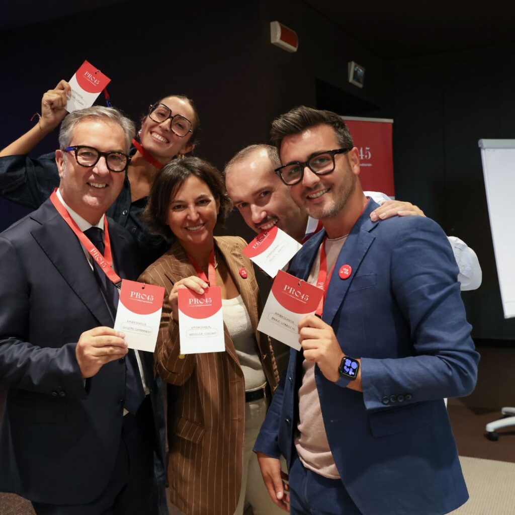 Partecipanti sorridenti con il materiale PRO45 durante il networking